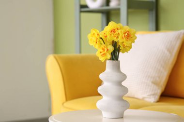 Sarı narsisli vazo oturma odasında, yakın plan.