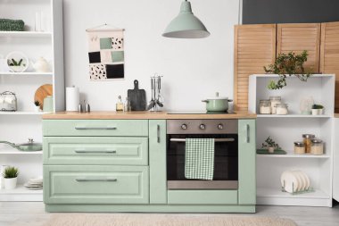 Mutfağın içinde beyaz tezgah ve fırın var.