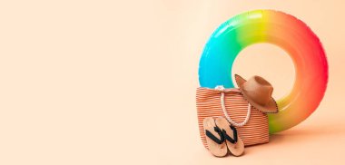 Bej arkaplanda şişirilebilir yüzük ve plaj aksesuarları ve metin için boşluk