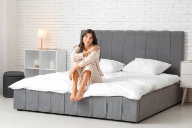 Yatağa evde oturan genç kadın