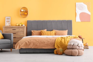 Sonbahar dekoru olan şık bir odada büyük, rahat bir yatak.