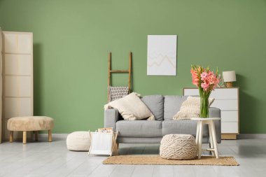 Masasında vazo ve gladyatör çiçekleri olan şık bir oturma odası.