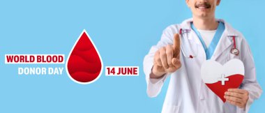 Kağıt kalpli bir erkek doktor mavi arka plandaki izleyiciyi işaret ediyor, yakın plan. Kan bağışı konsepti