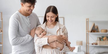 Küçük bebekleri olan genç ebeveynler yatak odasında.