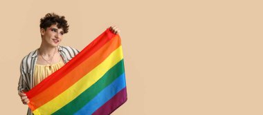 Bej arka planda LGBT bayrağı taşıyan genç bir transseksüel kadın.