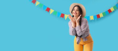 Genç mutlu kadın ve açık mavi arka planda bayraklar ve mesaj için yer. Festa Junina (Haziran Festivali) kutlaması