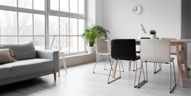 Kanepe, masa ve sandalyeli modern konferans salonu.