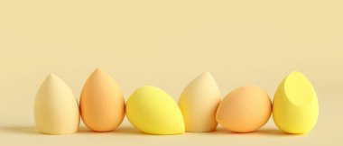 Sarı arka planda birçok makyaj süngeri