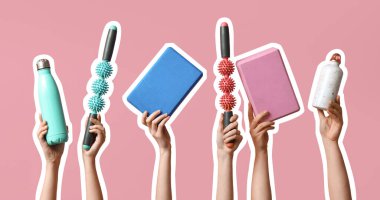 Yoga blokları, spor su şişeleri ve pembe arka planda paten çubukları olan kadın elleri.