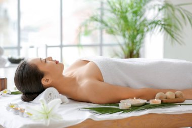 Genç Asyalı kadın spa salonunda dinleniyor.