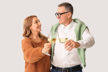 Beyaz arka planda şarap bardakları olan olgun bir çift.