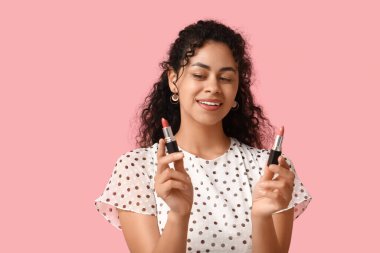 Pembe arka planda rujları olan güzel bir Afro-Amerikalı kadın.