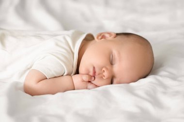 Sevimli küçük bebek yatakta uyuyor, yakın plan.