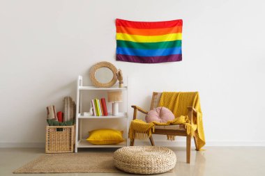 LGBT bayrağı, raf ünitesi ve koltuk olan oturma odasının içinde.