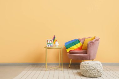 Koltuk, masa ve LGBT bayraklı odanın içi