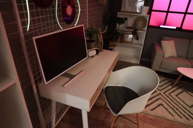 Podcaster 'ın karanlık stüdyodaki bilgisayarlı iş yeri