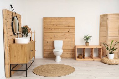 Lavabosu, aynası ve klozeti olan bir tuvalet.