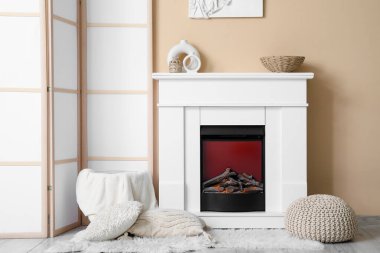 Şömine, yastıklar ve ışık oturma odasının iç tarafında katlanan perdeler.