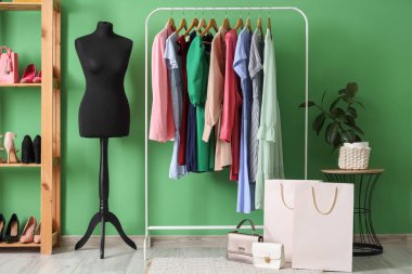 Manken, giysi askılığı ve raf ünitesi olan soyunma odasının içinde.