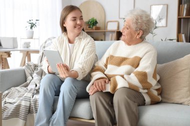 Mutlu son sınıf öğrencisi ve torunu evdeki kanepede oturuyorlar.