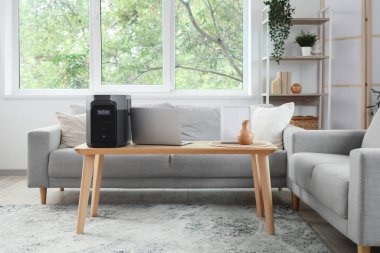 Oturma odasının içinde koltuklar ve portatif elektrik santrali var.