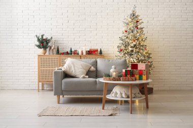 Oturma odasının içinde kanepe, parlayan Noel ağacı ve masada Advent takvimi.