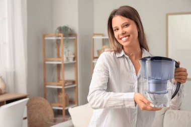 Su filtresi sürahisi olan genç bir kadın.