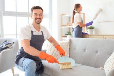 Erkek hademe odayı süpürüyor.