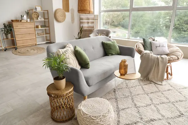 Yumuşak kanepesi, koltuğu, sehpası ve penceresi olan rahat bir oturma odası.