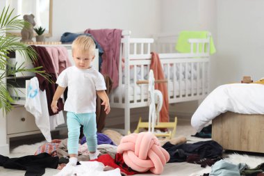 Yaramaz bebek yatak odasında yürüyor.