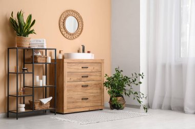 Lavabosu, raf ünitesi ve yanan mumları olan banyonun içi.