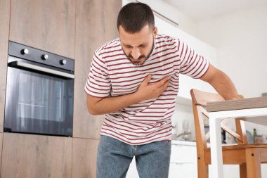 Evdeki masada kalp krizi geçiren genç bir adam.