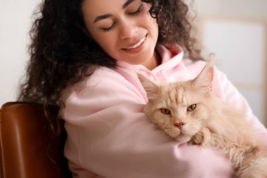 Güzel, genç, mutlu, Afro-Amerikan bir kadın ve sevimli Maine Rakun kedisi.