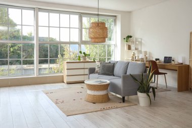 Programcı işyeri, kanepe ve çekmeceleri olan aydınlık oturma odasının içinde.