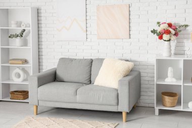 Raflarda güzel dekolteli çiçeklerle aydınlık oturma odasının şık iç mekanı.