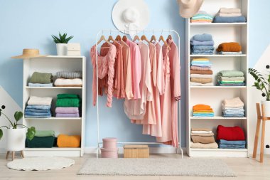 Soyunma odasında elbise ve askılar var.