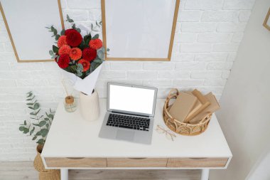 İş yerindeki vazoda, oturma odasındaki dizüstü bilgisayarın yanında bir buket yıldız çiçeği var.