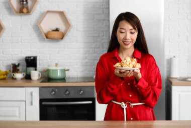 Evde fal kurabiyesi olan genç Asyalı kadın.