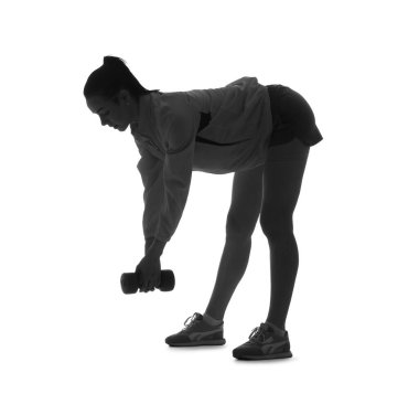 Beyaz arka planda dambılla egzersiz yapan genç bir kadının silüeti.