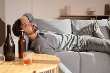 Kanepede yatan sarhoş adam. Alkolizm kavramı