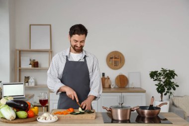 Mutfakta kabak kesen yakışıklı sakallı adam.