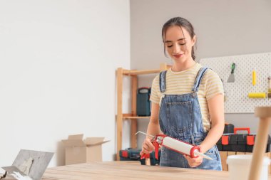 Masasında dolgu macunu olan genç bir kadın var.