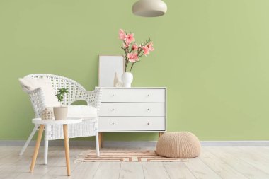 Oturma odasının içinde vazoda koltuk, klozet ve manolya çiçekleri var.