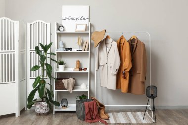 Katlanmış perdeli giyinme odası, raflar ve giysi rafları.