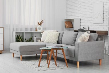 Oturma odasının iç tarafında rahat bir kanepe ve cam sehpa.