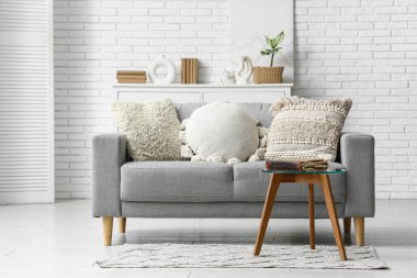 Oturma odasındaki kanepenin yanındaki masada eski bir kitap.