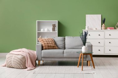 İçinde güzel lavanta çiçekleri ve modern oturma odasının içinde rahat bir kanepe olan vazo.