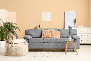 Masanın üzerinde rahat kanepe ve lavanta çiçekleri olan modern oturma odasının şık bir iç mekanı.