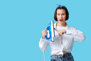 Mavi arka planda demire dokunan genç kadın