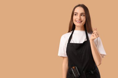 Genç kuaför bej arka planda parmaklarıyla kalp yapıyor.